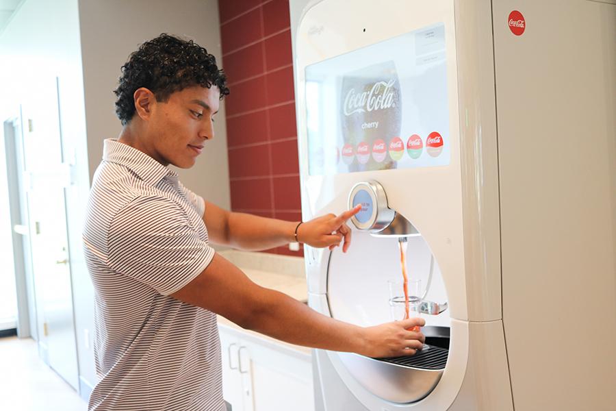A student pours a soda from the machine.