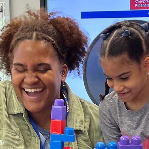 A speech student teacher has a joyous moment with a young student.