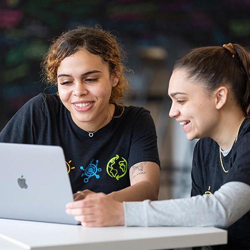 Two entrepreneur students work on a laptop in the Hynes Institute.