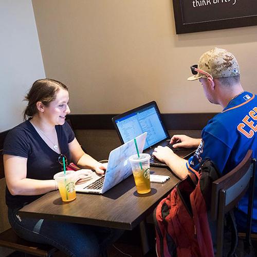 Students study remotely in a cafe.