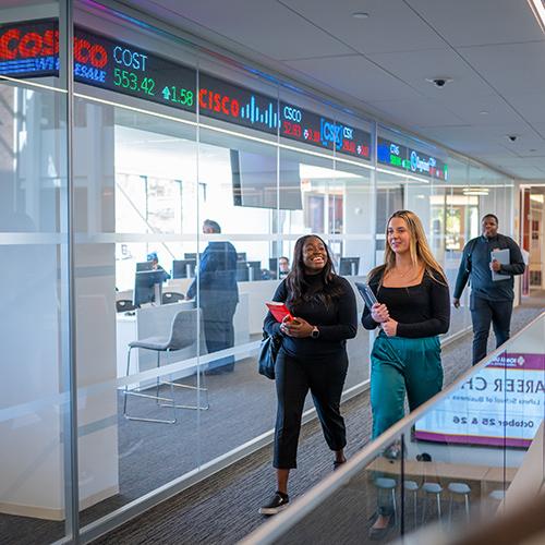 Students walk by the trading floor in LSB.