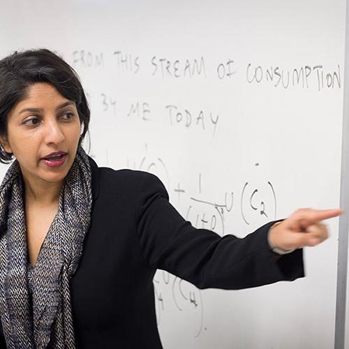 A professor works at the whiteboard in class.