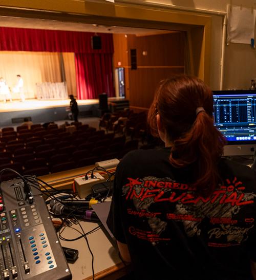 Students in the tech booth at a play rehearsal.