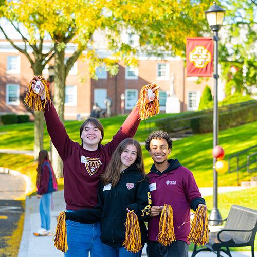 Three students greet visitors to campus.