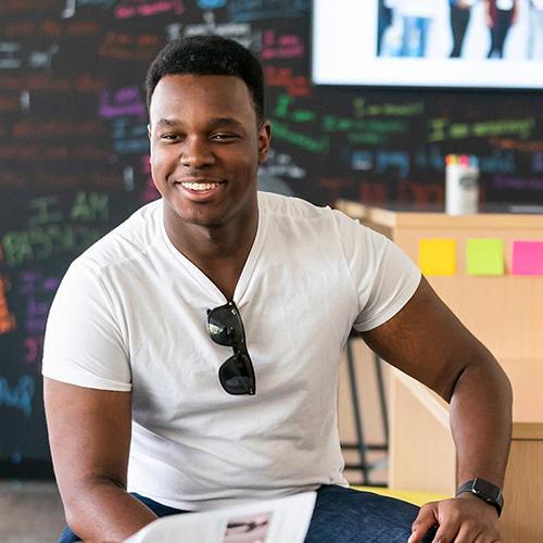 An entrepreneurship student smiles in class.