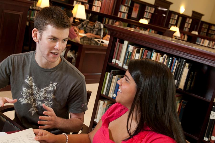 Two students discuss a text in the Ryan Library.