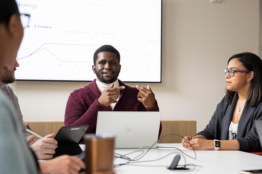 Verrick presents in a business class.