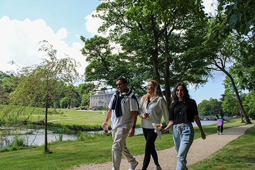 Three students walk outside near the Westport House.
