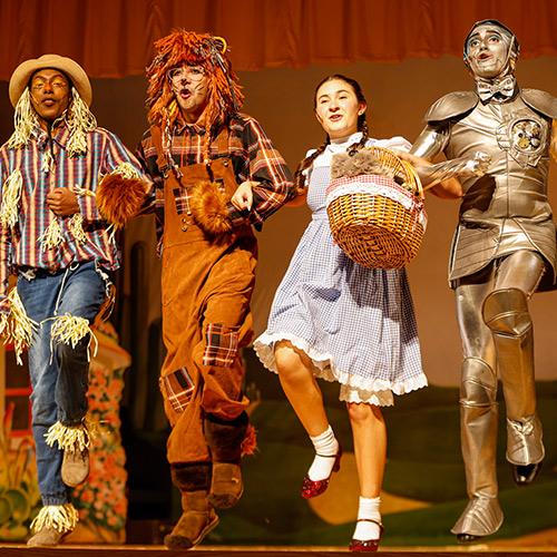Four students perform The Wizard of Oz.