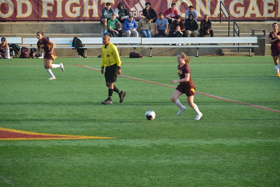 A member of women's club soccer drives down the field.