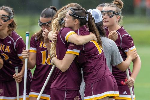 Members of the women's club lacrosse team embrace after a game.